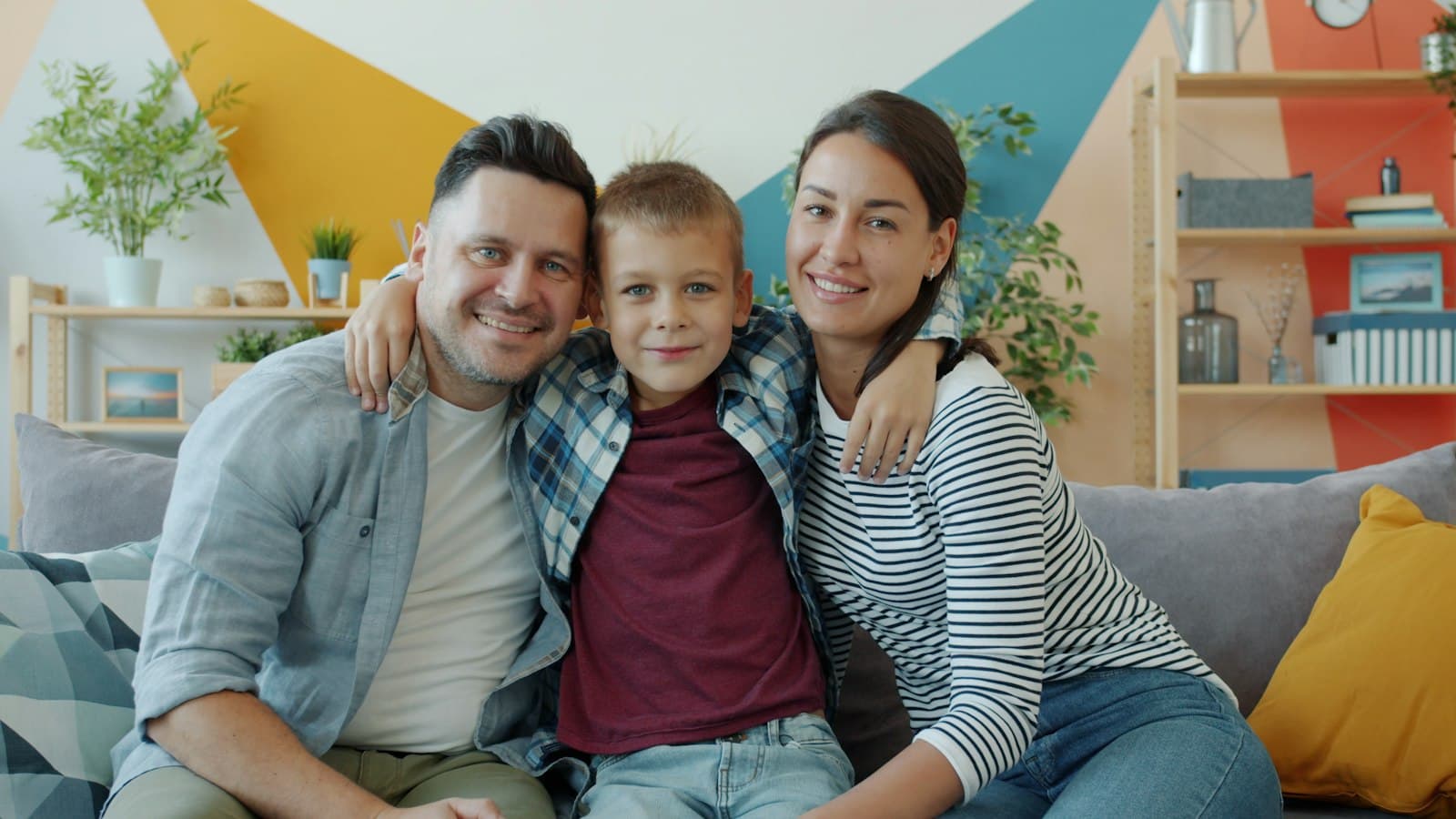 Família sorrindo no sofá de casa